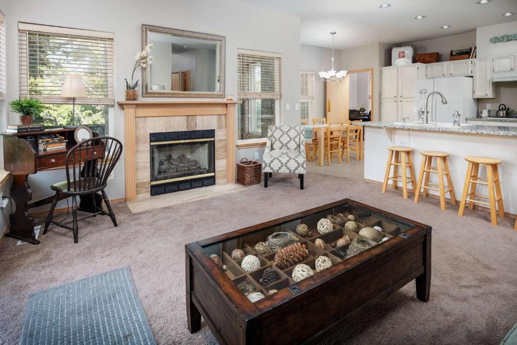 ein Wohnzimmer mit einem Kamin und einem Tisch in der Unterkunft Cooper Mountain Retreat in Hazeldale