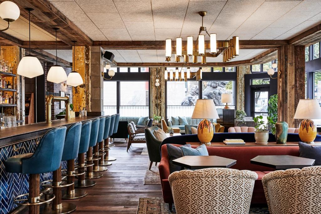 a restaurant with blue chairs and a bar at The Hoxton, Portland in Portland