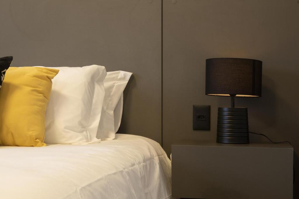 una camera da letto con un letto con una lampada su un comodino di BEN - Flats Completos com Limpeza Diária e Estacionamento Incluso a San Paolo