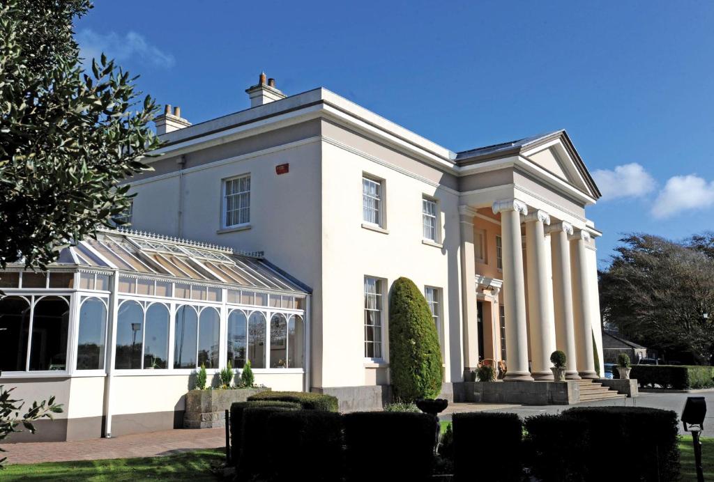 a large white house with a conservatory at Best Western Lamphey Court Hotel and Spa in Lamphey