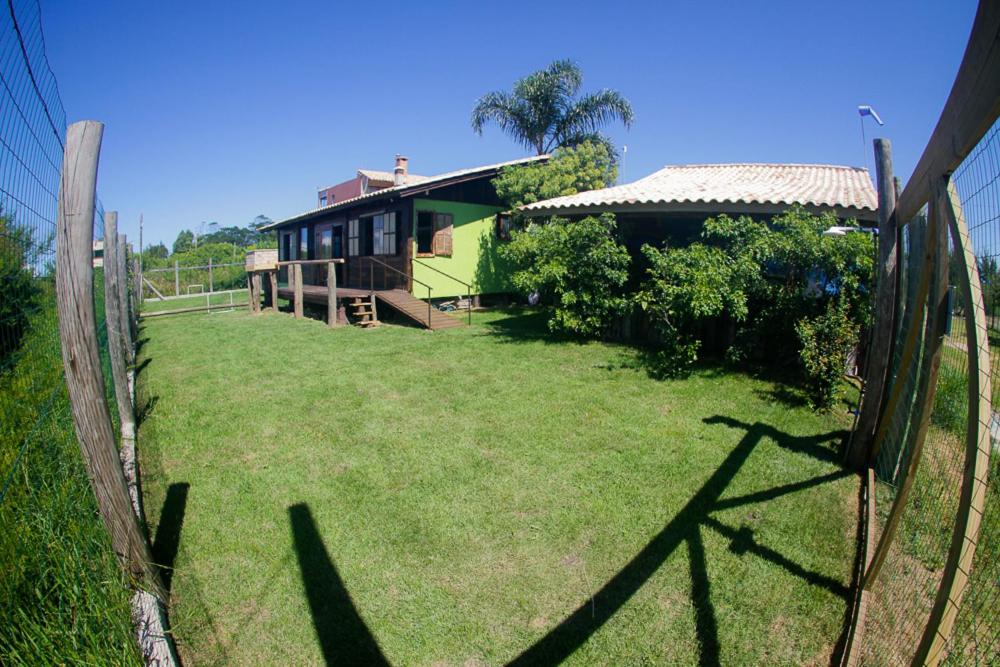a fence in front of a house with a yard at Cigana's House 1 - Região do Farol de Santa Marta in Laguna
