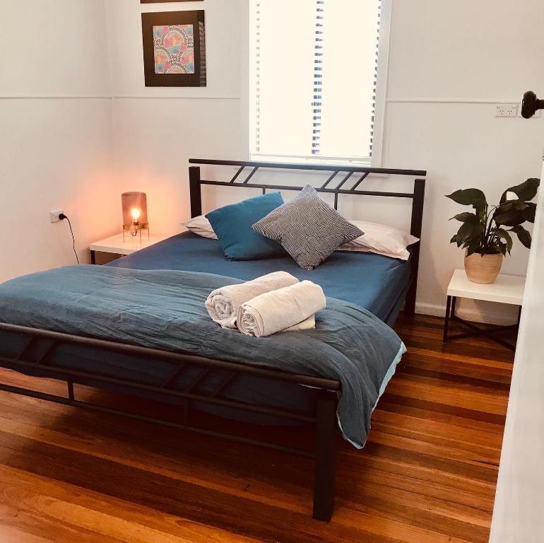 a bedroom with a bed with two towels on it at Ella May Holiday Flats in Tuross Heads