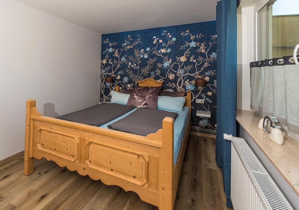 a bedroom with a wooden bed with a blue wall at Fewo Tante Else in Bodenwerder