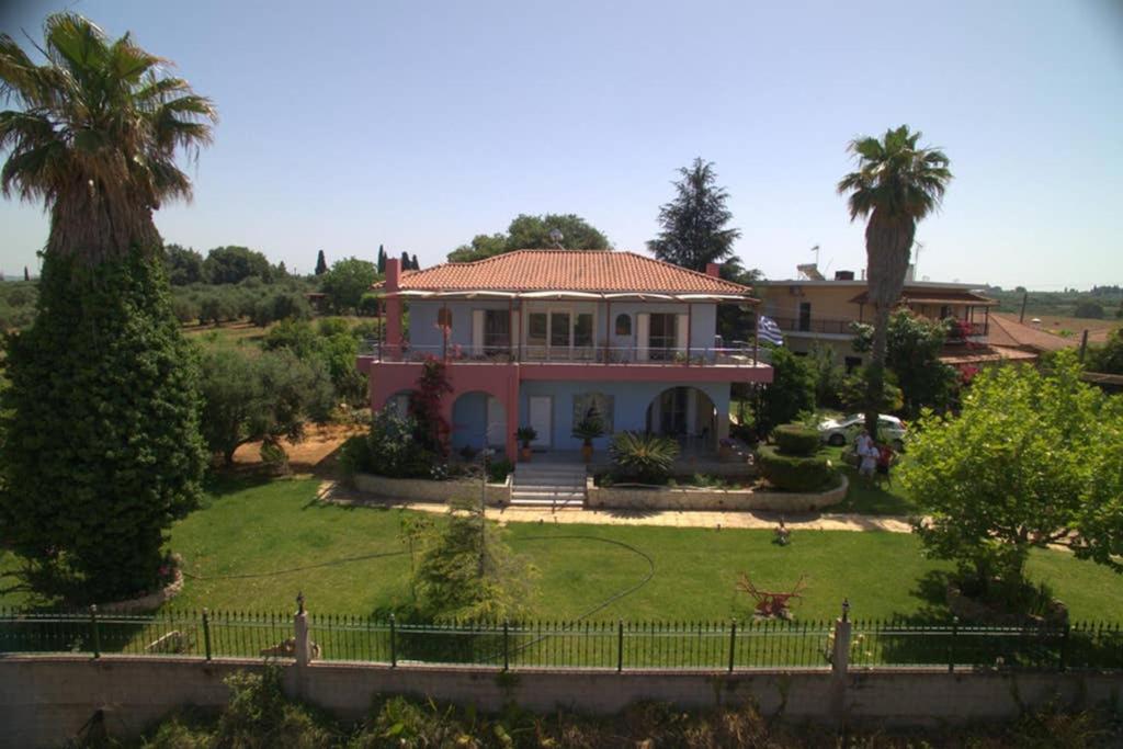 une maison avec une grande cour ornée de palmiers dans l'établissement Giorgos house, à Dhounaíika