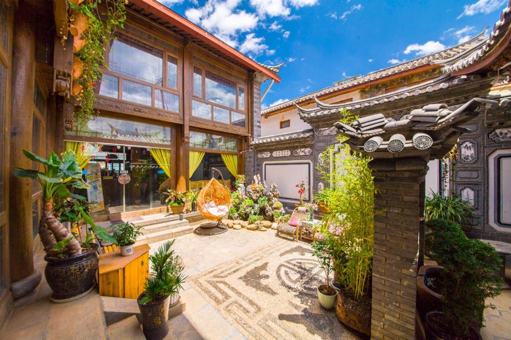 a house with a courtyard with potted plants at Dreamer Inn in Lijiang