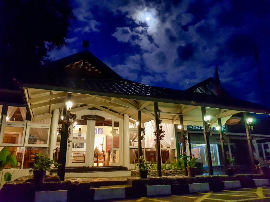 a building at night with the moon in the sky at Sutera Sanctuary Lodges At Poring Hot Springs in Ranau