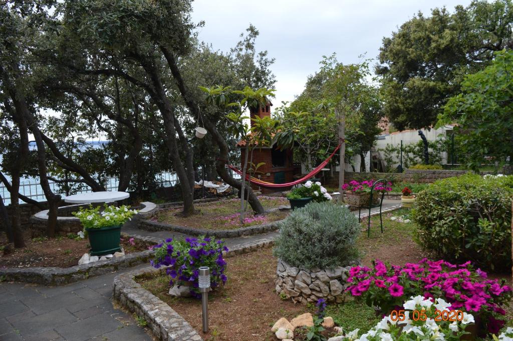 a garden with flowers and a swing at Apartment PALATISA in Kožino