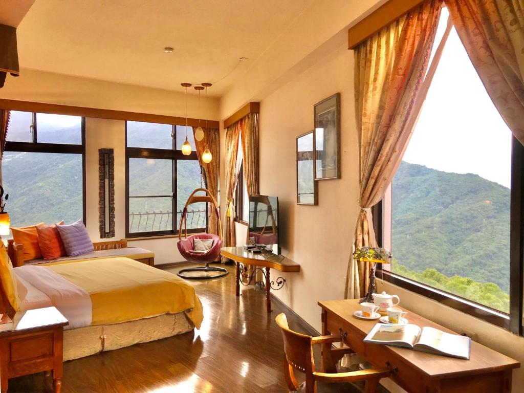 a bedroom with a bed and a large window at Margaret Garden Villa in Ren&#39;ai