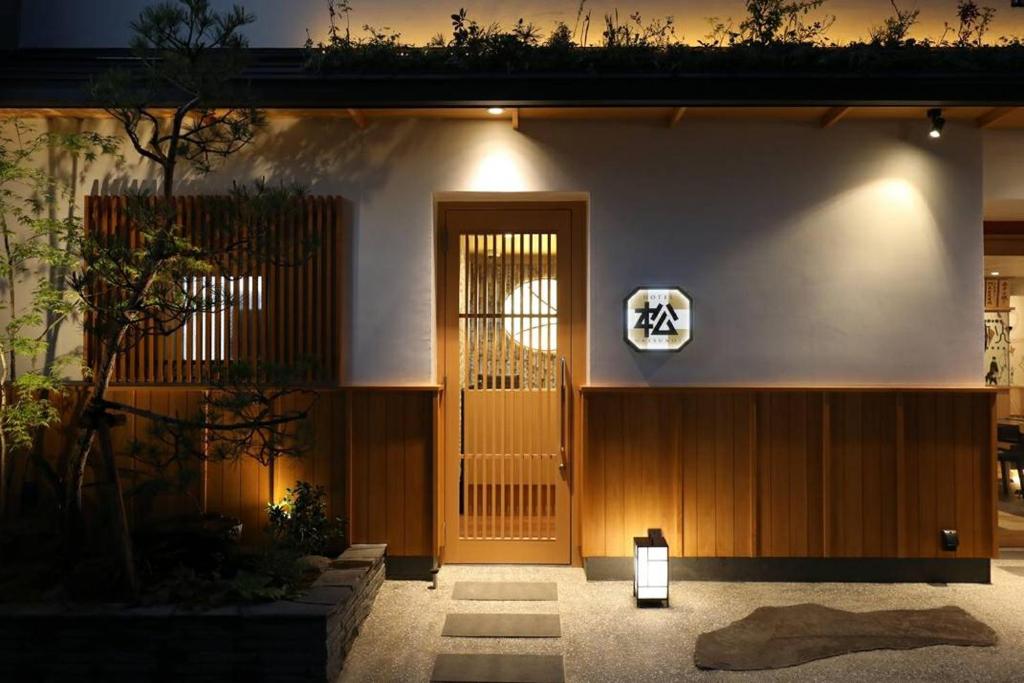 un edificio con una puerta con un cartel. en Hotel Matsunoi en Tokio