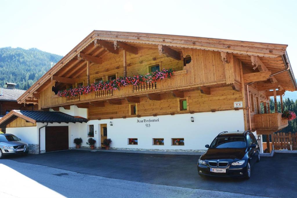 a car parked in front of a building with a balcony at Haus Dorferstuck in Alpbach
