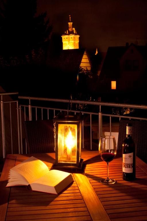 a candlelit table with a book and a glass of wine at Ferienhaus - die710 in Rothenburg ob der Tauber