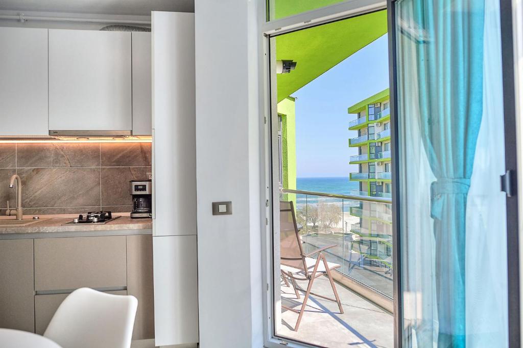 a kitchen with a balcony with a view of the ocean at Sea Love apt SPA n Pools Beach Resort in Mamaia Nord