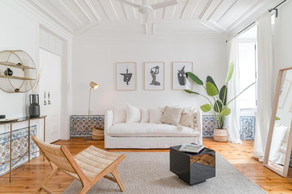 a living room with a white couch and a table at Casa Boma Lisboa - Typical and Spacious Apartment - Lapa II in Lisbon