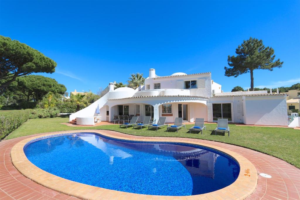 a villa with a swimming pool in front of a house at Vila Girasol, 171 - Clever Details in Vilamoura