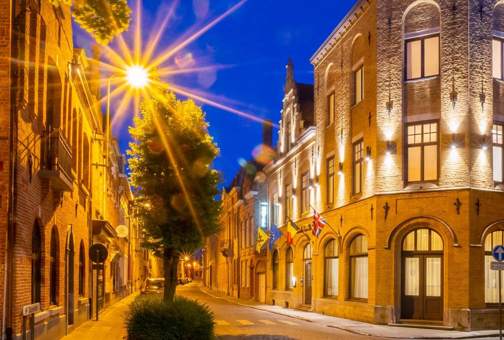 an empty street in an old city at night at Albion Hotel in Ieper