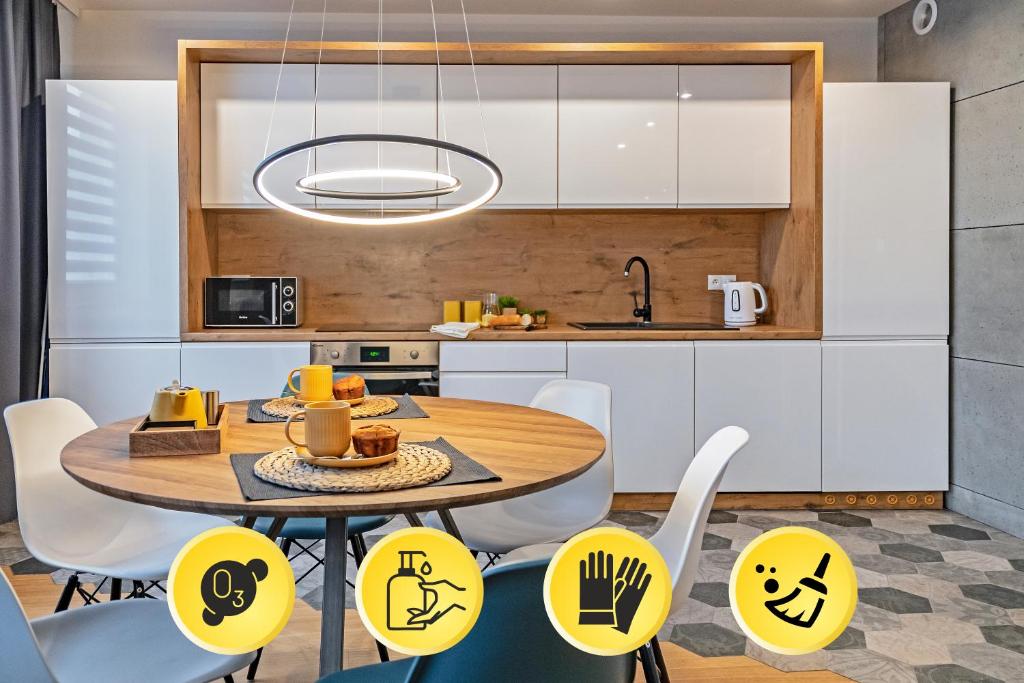 a kitchen with a table and chairs with smileys on them at 3D KOSCIUSZKI 19 Apartament in Kraków