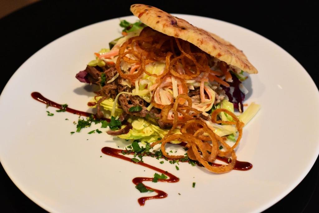 a white plate of food with a salad on it at Romantik Hotel Schwan in Horgen