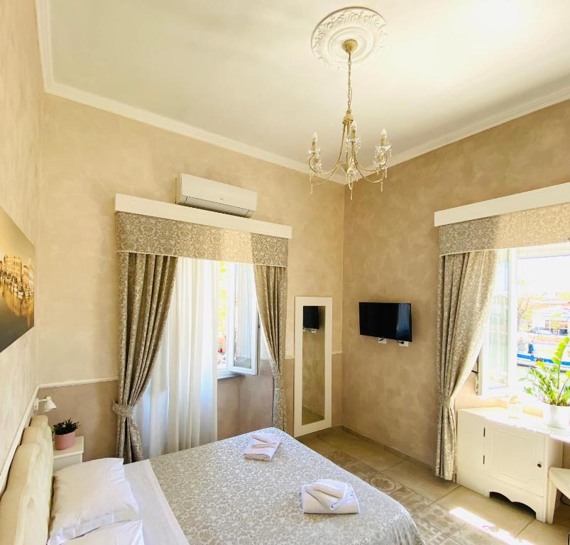 a bedroom with a bed and a chandelier at Domus Valadier B&B Guesthouse in Fiumicino