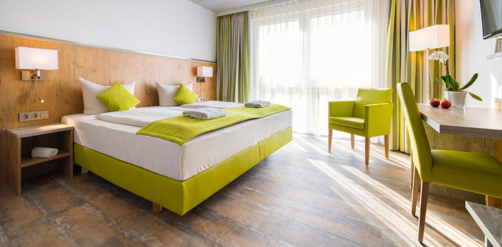 Habitación de hotel con cama, mesa y sillas en OHO Rooms Herrenberg Digital Access Only, en Gäufelden