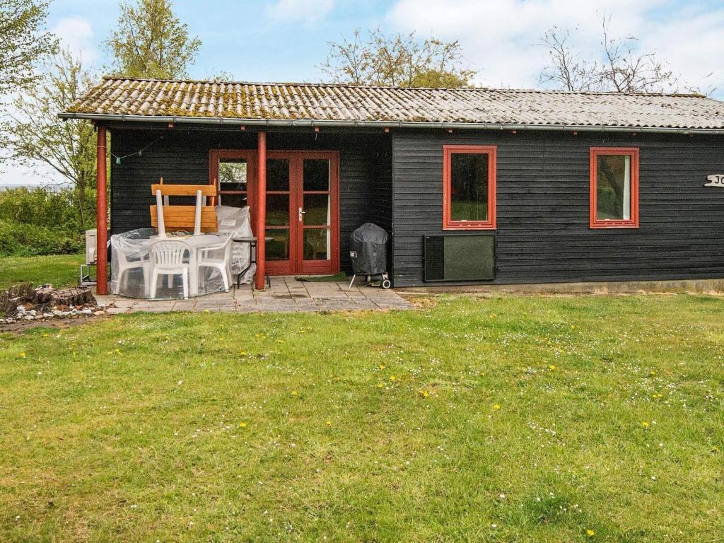 mały czarny dom z patio i stołem w obiekcie 6 person holiday home in Nordborg w mieście Nordborg