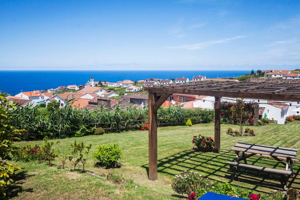 a bench in a yard with a view of the ocean at Casa da Courela in Nordeste