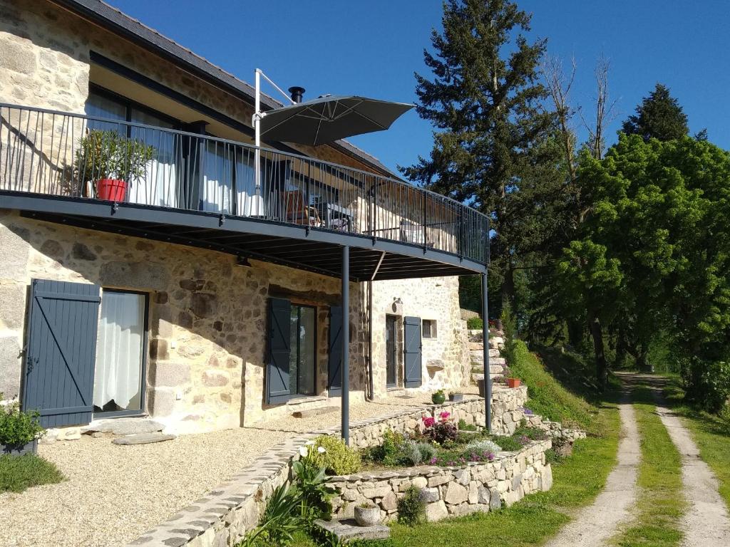 a stone house with a balcony and a patio at La Fournial in Lunac