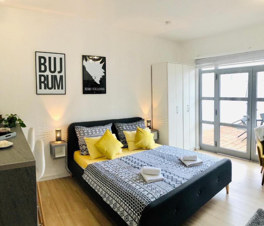 1 dormitorio con 1 cama grande con almohadas amarillas en Dream Apartments, en Mostar