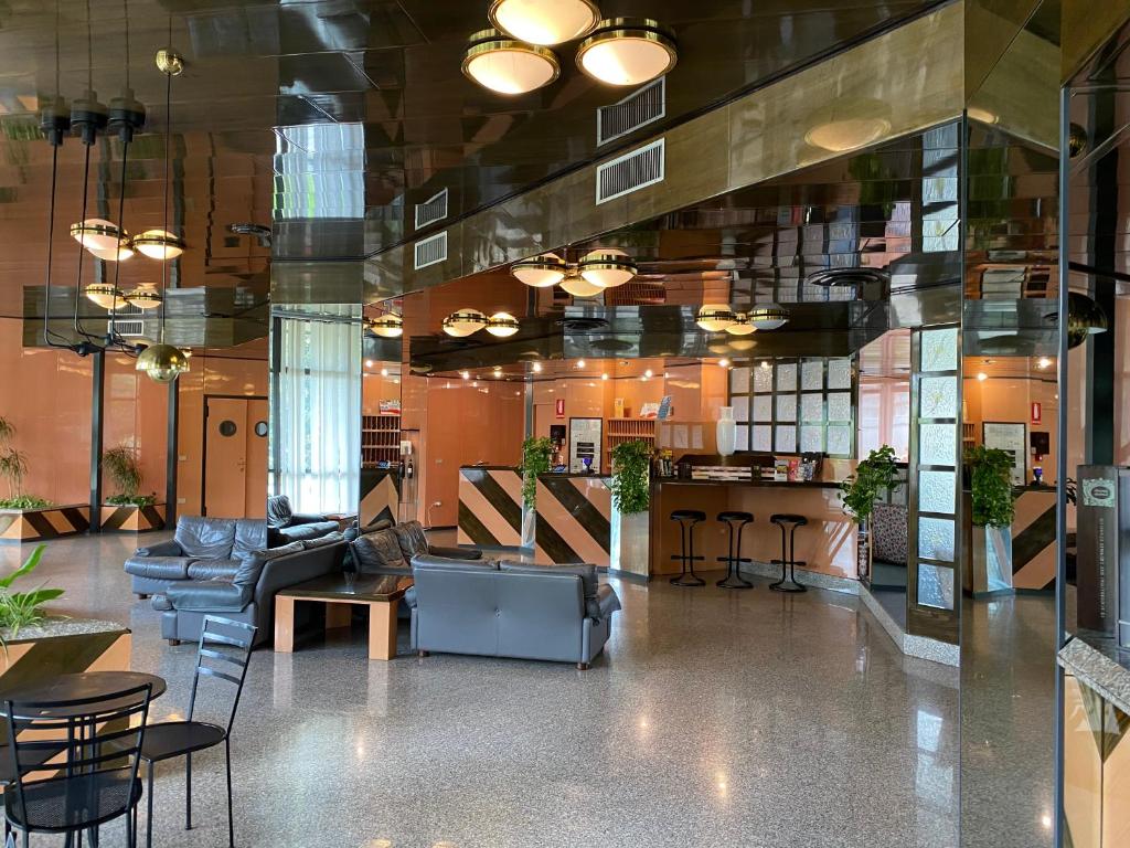 een lobby met een bank en stoelen en een bar bij Hotel i Ciliegi in Reggello
