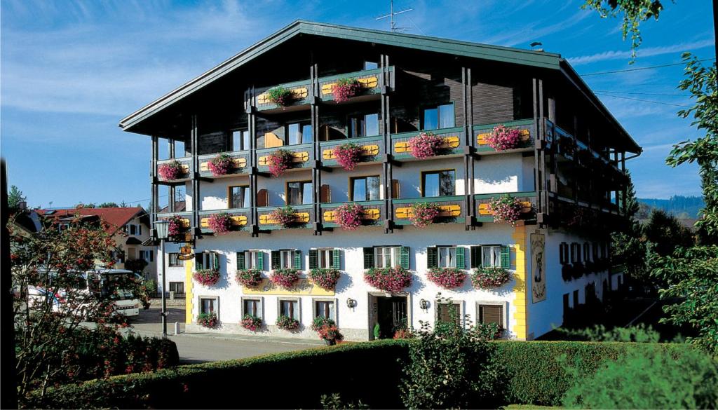 un gran edificio con flores. en Tirolerhof, en Sankt Georgen im Attergau