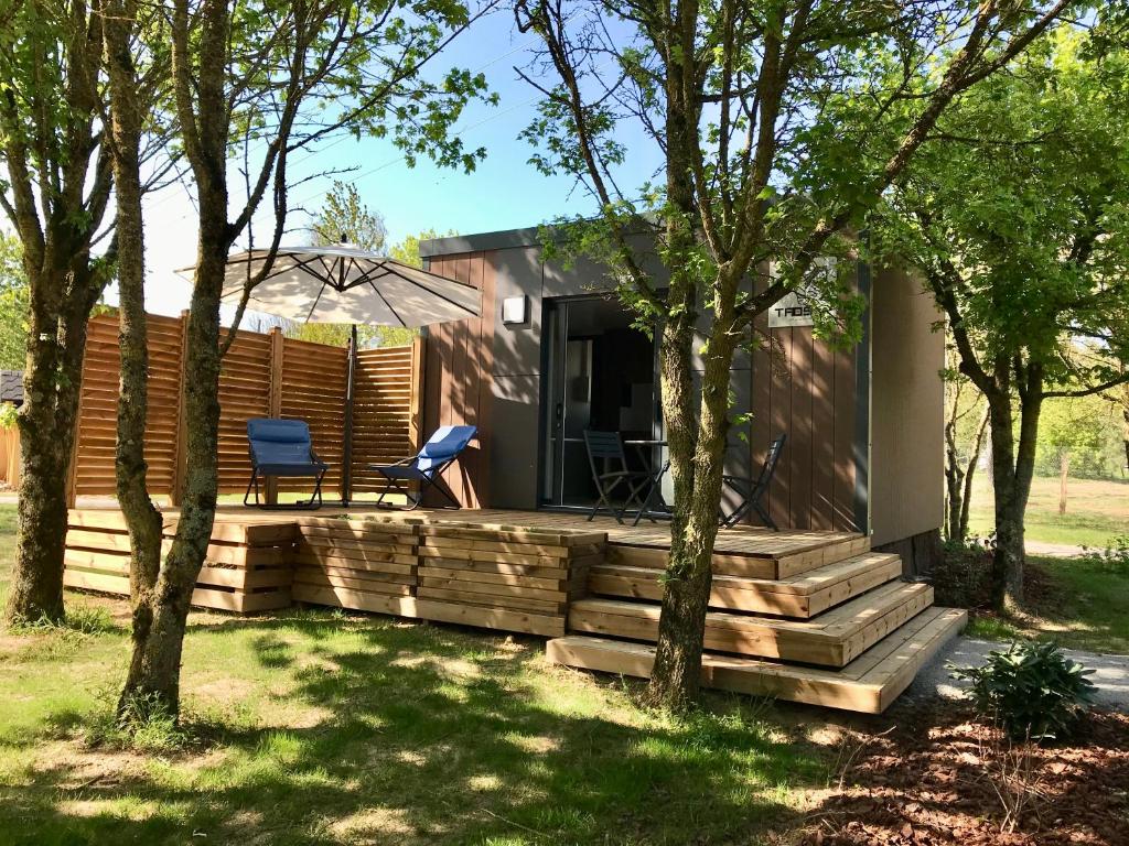 ein modulares Haus mit einer Terrasse und Bäumen in der Unterkunft Cottage du garlai in Bressuire