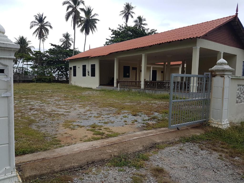 uma casa com um portão em frente em The Kallang House em Kuala Terengganu