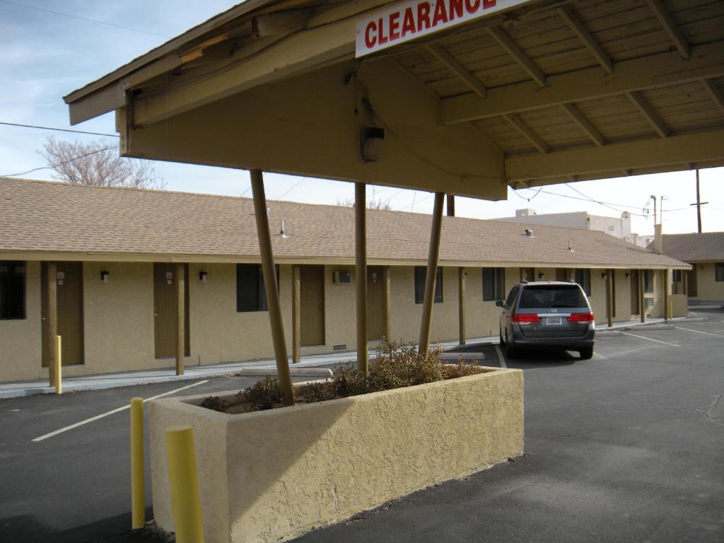 a car parked in a parking lot in front of a garage at Lone Pine Budget Inn in Lone Pine
