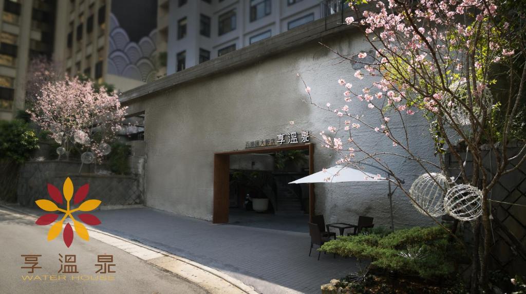 a building with a table and an umbrella on a street at Water House in Taipei