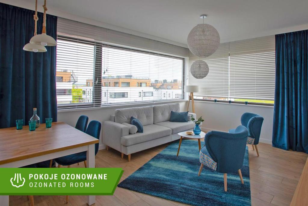 a living room with a couch and a table at Apartament Zefir Mechelinki in Mechelinki