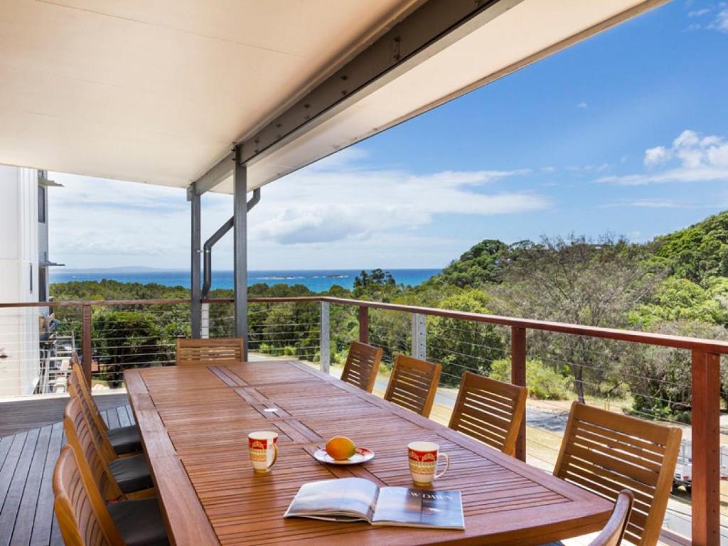 a wooden table on the balcony of a house at 19a George Nothling Drive in Point Lookout