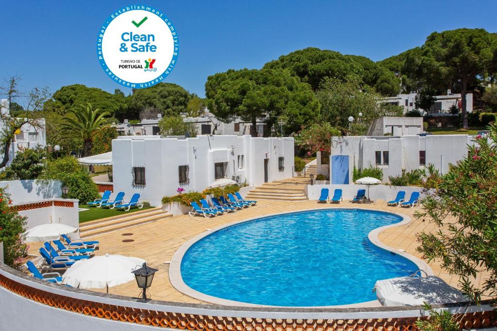 a pool at the villa with a sign that says clean and safe at Prado do Golf in Vilamoura