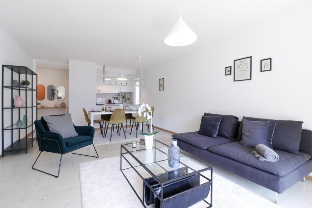 ein Wohnzimmer mit einem blauen Sofa und einem Tisch in der Unterkunft Nice apartment ideally located in Martigny in Martigny-Ville