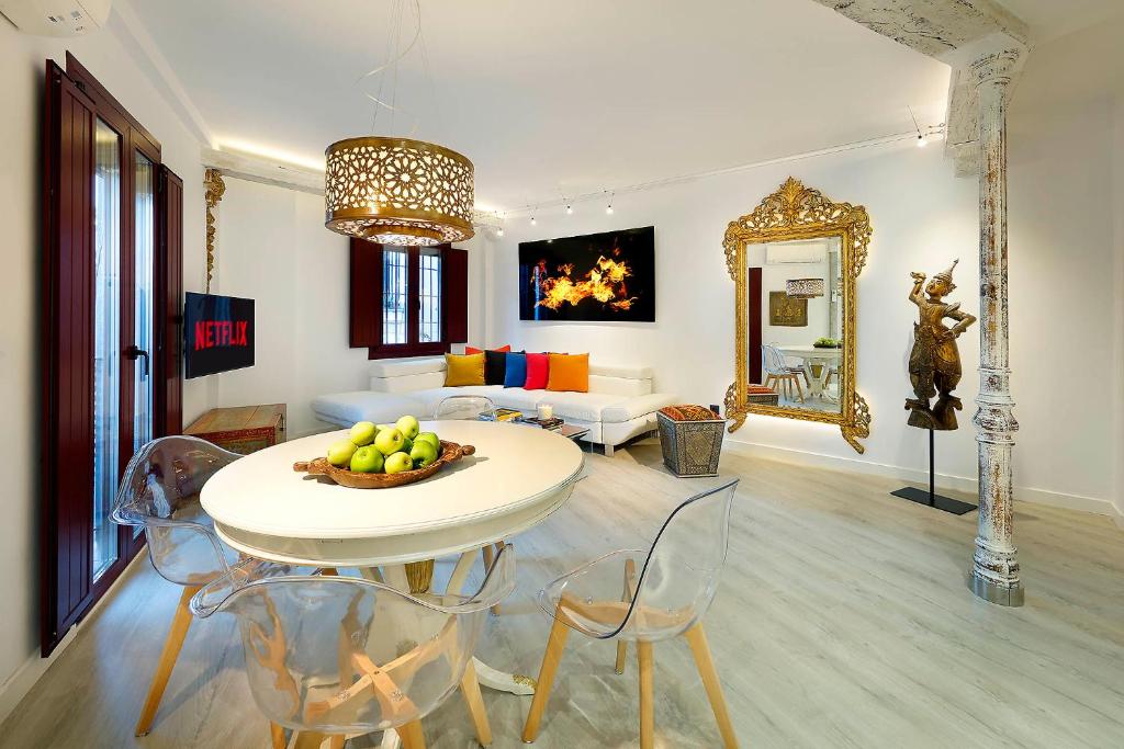 ein Wohnzimmer mit einem Tisch, Stühlen und einem Sofa in der Unterkunft Art Chapiz Apartments in Granada