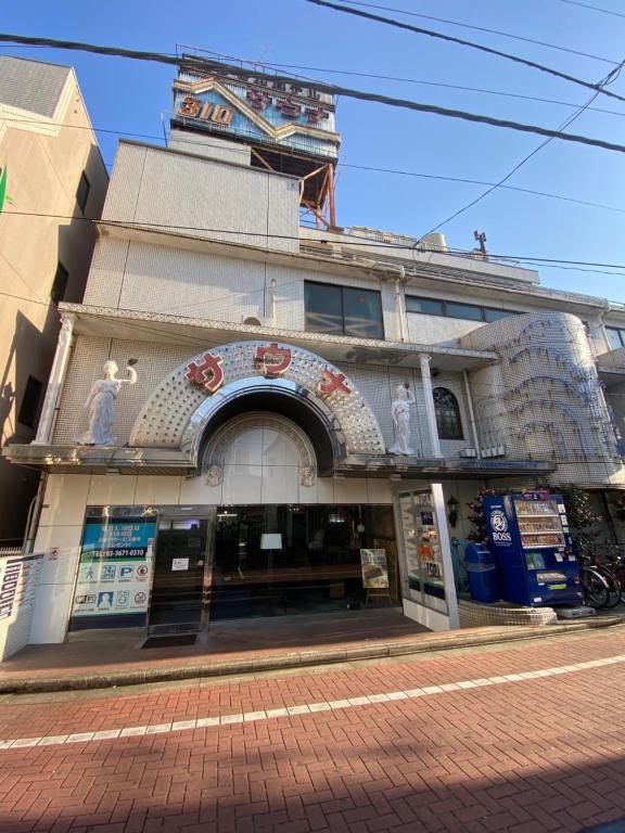 a building with an archway in front of a street at Capsule Hotel 310 in Tokyo