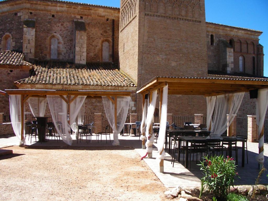 a patio with tables and chairs in front of a building at Complejo Rural Lifara in Aniñon