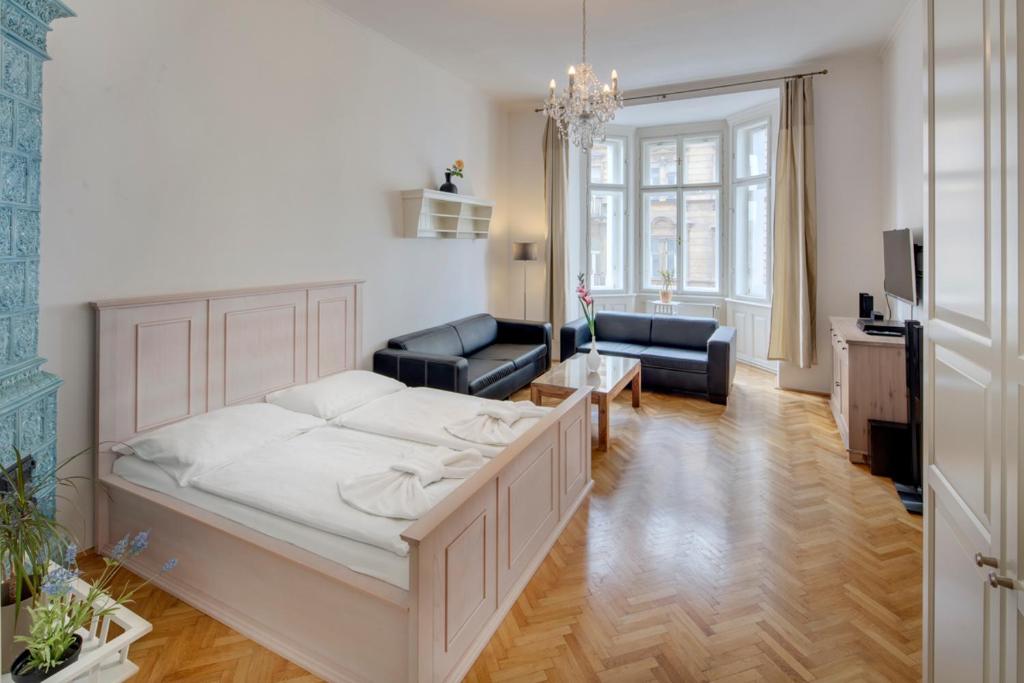 um quarto com uma cama e um sofá e uma sala de estar em Kaprova 5 - Old Town Apartments em Praga