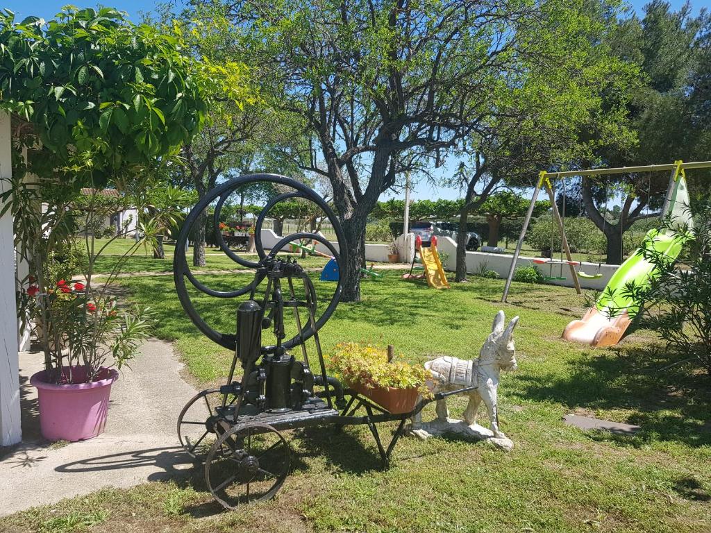 posąg osła ciągnącego wózek z koszem kwiatów w obiekcie Le Mas de Mon Pere w Saintes-Maries-de-la-Mer