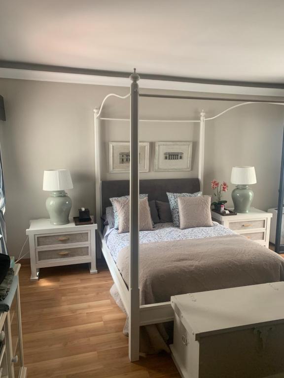een slaapkamer met een wit bed met 2 tafels en 2 lampen bij Banus Lovely Apartment in Marbella