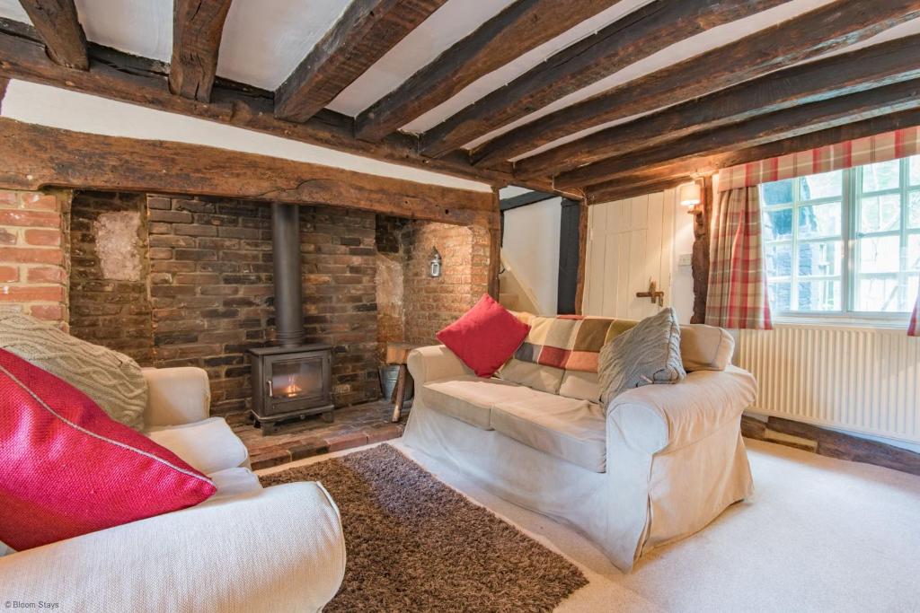 ein Wohnzimmer mit zwei Sofas und einem Kamin in der Unterkunft Walnut Tree Cottage by Bloom Stays in Faversham