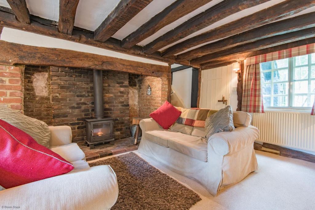 a living room with two couches and a fireplace at Walnut Tree Cottage by Bloom Stays in Faversham