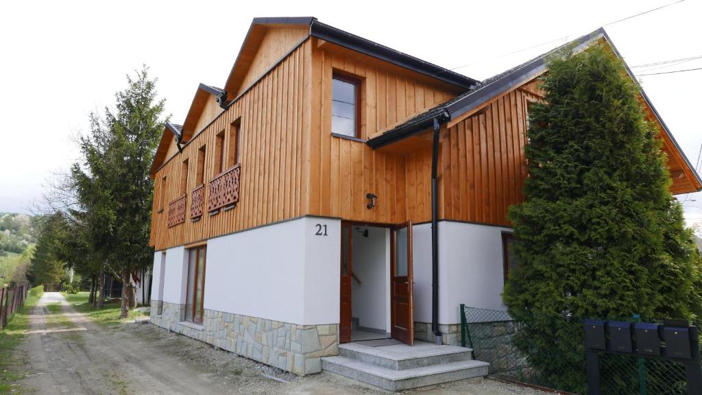 uma casa de madeira com uma garagem branca em Apartament Hanka em Krościenko