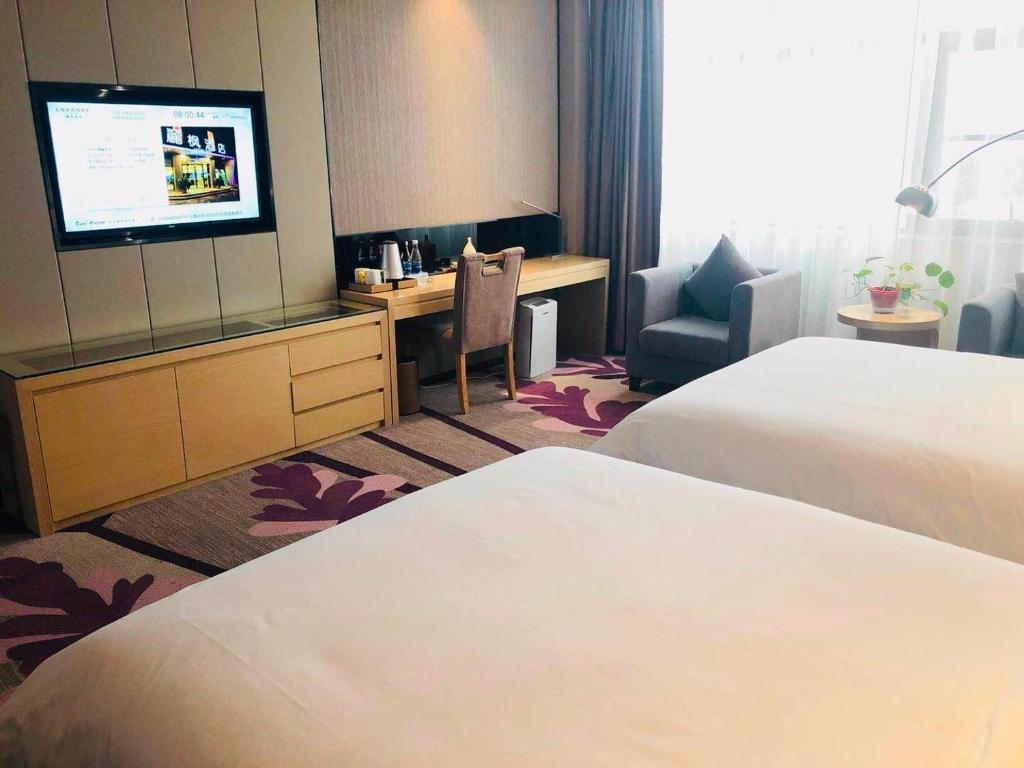 a hotel room with two beds and a flat screen tv at Lavande Hotel Zhengzhou Economic Zone International Logistics Park in Zhengzhou