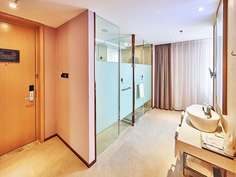 La salle de bains est pourvue d'un lavabo et d'une douche en verre. dans l'établissement Lavande Hotel Changchun Peoples Square, à Changchun