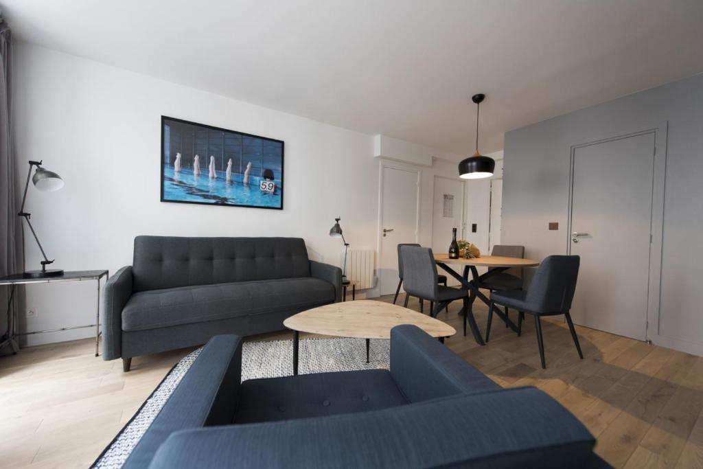 ein Wohnzimmer mit einem Sofa und einem Tisch in der Unterkunft Magnum in Paris