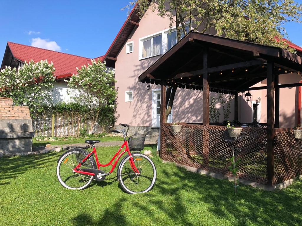 Una bicicleta roja estacionada en el césped frente a una casa en Holiday Home GC30 en Cristian